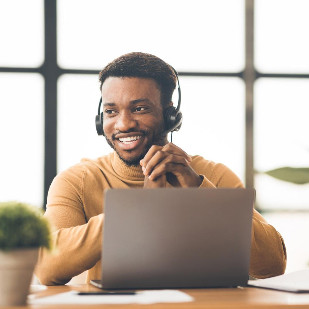 Man on computer with headset